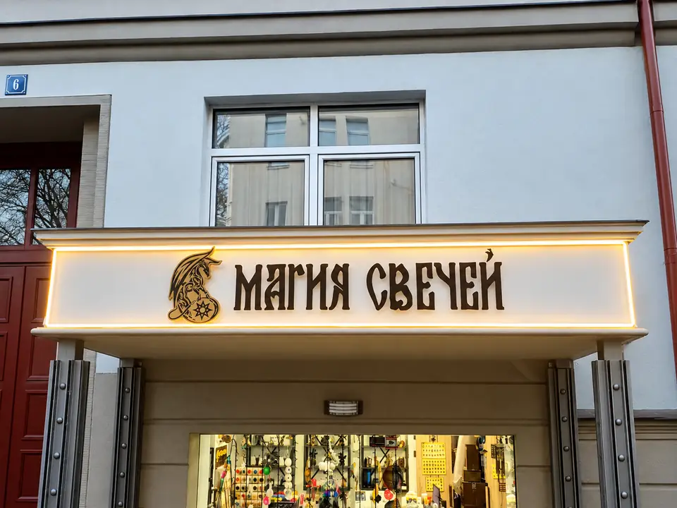 Вывеска магазина «Магия свечей» со световым контуром над входом