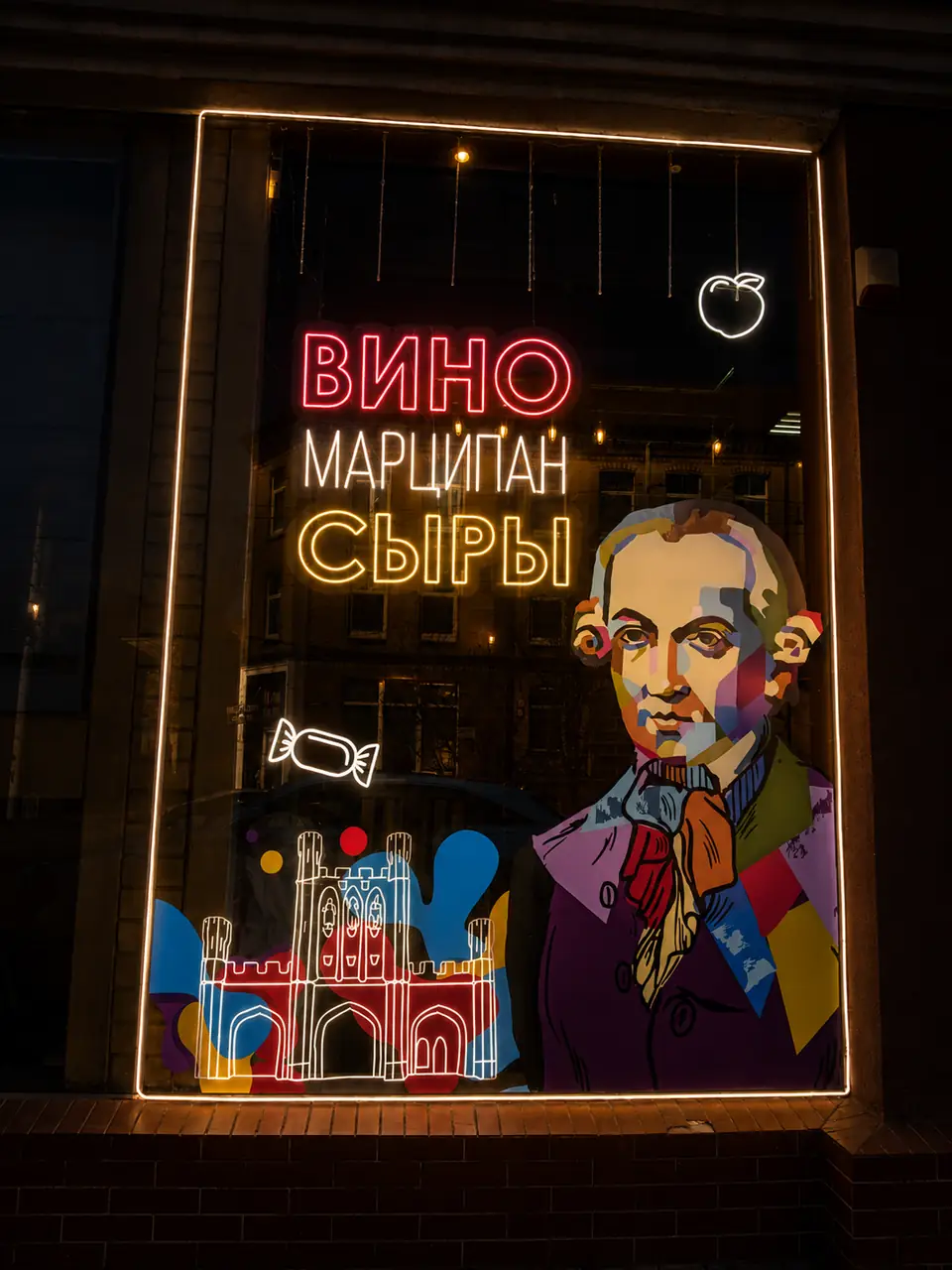 Неоновые надписи «Вино», «Марципан», «Сыры» на оформленной витрине