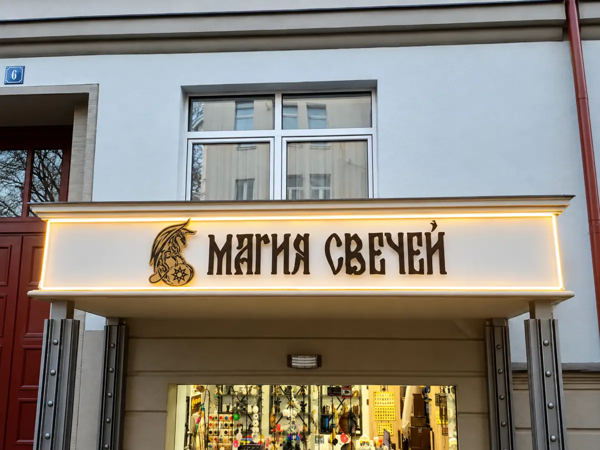 Чёрные несветовые буквы «Магия свечей» на окрашенном фасадном фризе