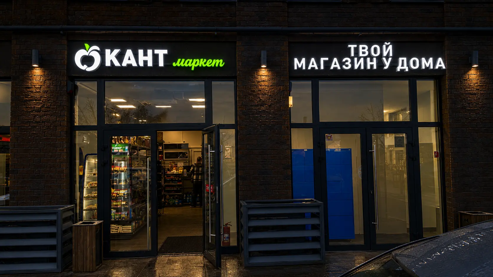 Световая вывеска Кант Маркет на кирпичном фасаде вечером